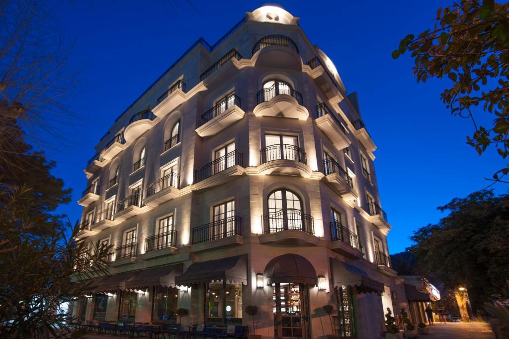 فندق ماجستيك في بودفا: مبنى أبيض كبير مع نوافذ في الليل