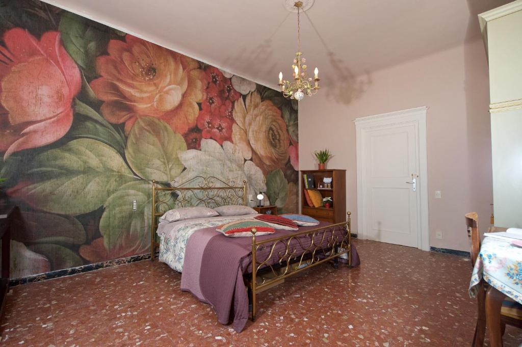 ルッカにあるLiberi Mercanti - guest house affittacamereの花の壁画が壁に施されたベッドルーム