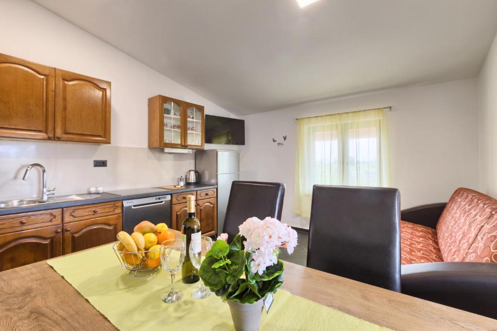 uma cozinha com uma mesa com um vaso de flores em Apartments Ines em Pula