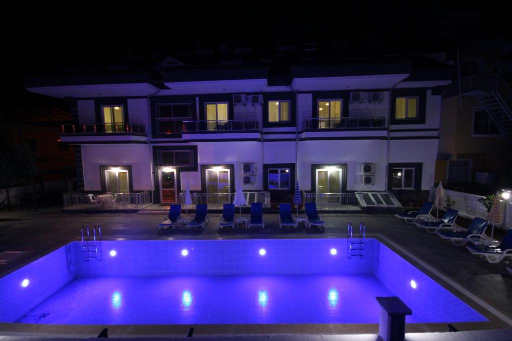 a house with a swimming pool at night at Stella City Apartments in Fethiye