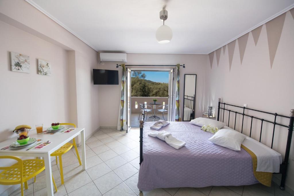 a bedroom with a bed and a table and a room at Alexandros in Lefkada
