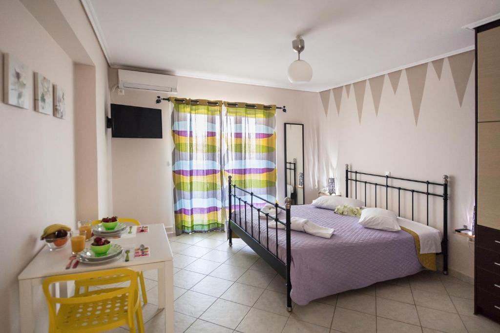 a bedroom with a bed and a table and a desk at Alexandros in Lefkada Town