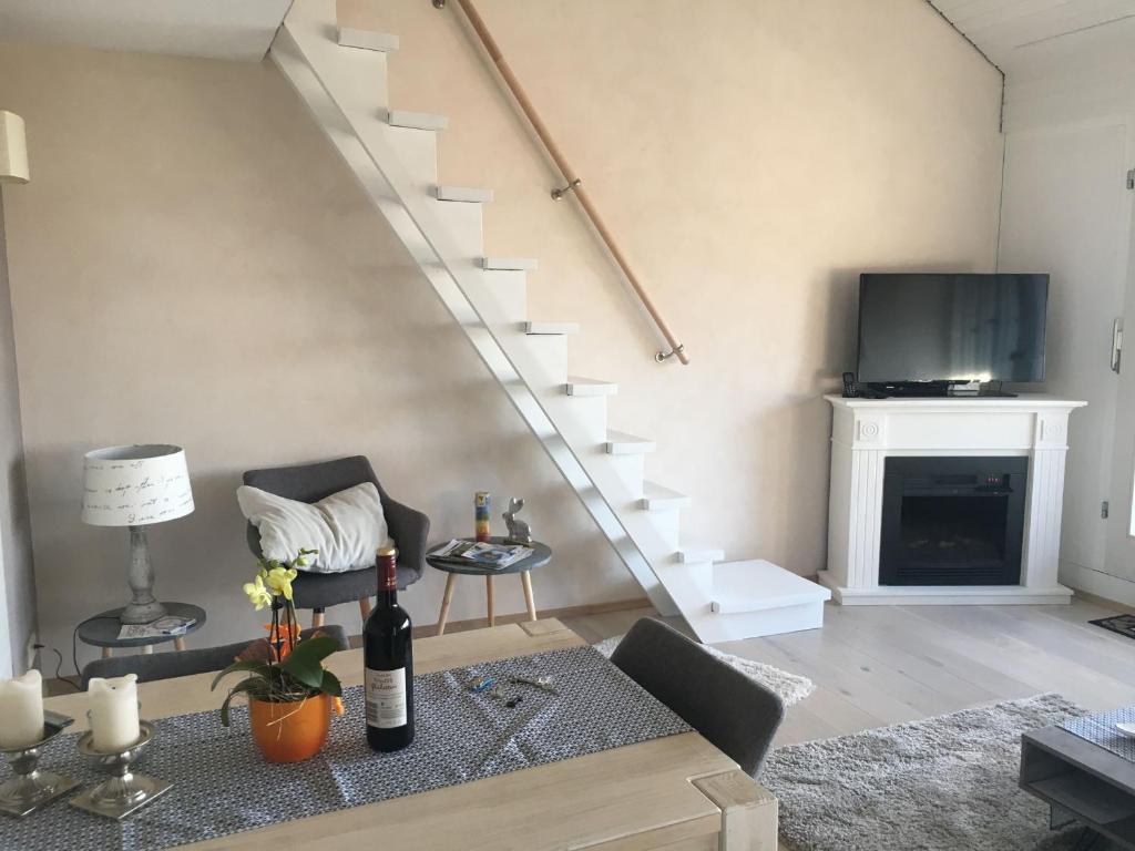 a living room with a couch and a tv and stairs at Auszeitwohnung Black Forest in Sasbachwalden