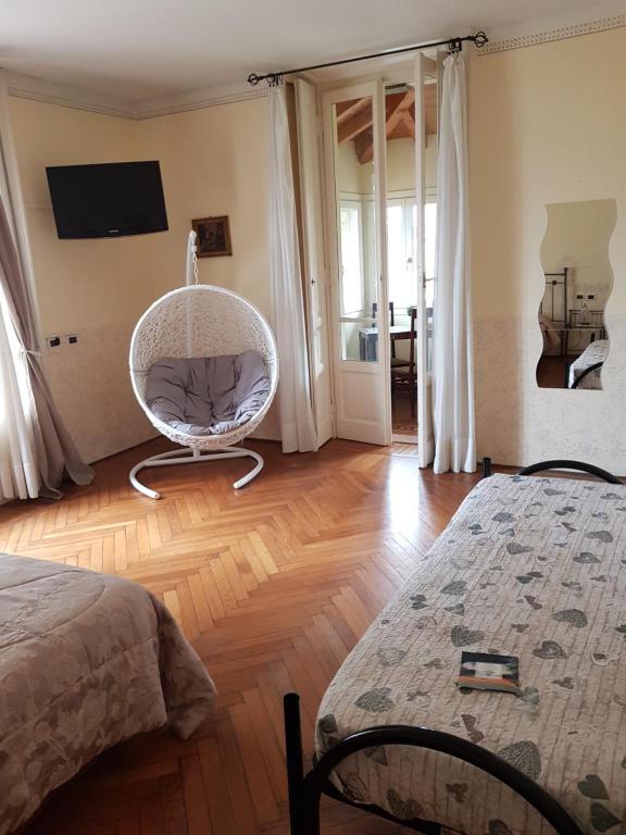 ein Schlafzimmer mit einem weißen Stuhl in einem Zimmer in der Unterkunft Alla Torretta in Bellagio