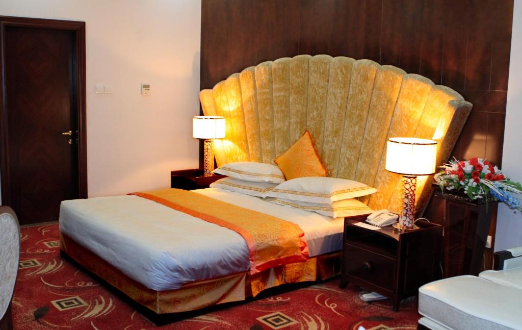 a hotel room with a bed with a large headboard at Kabul Star Hotel & Restaurant in Shīrpūr