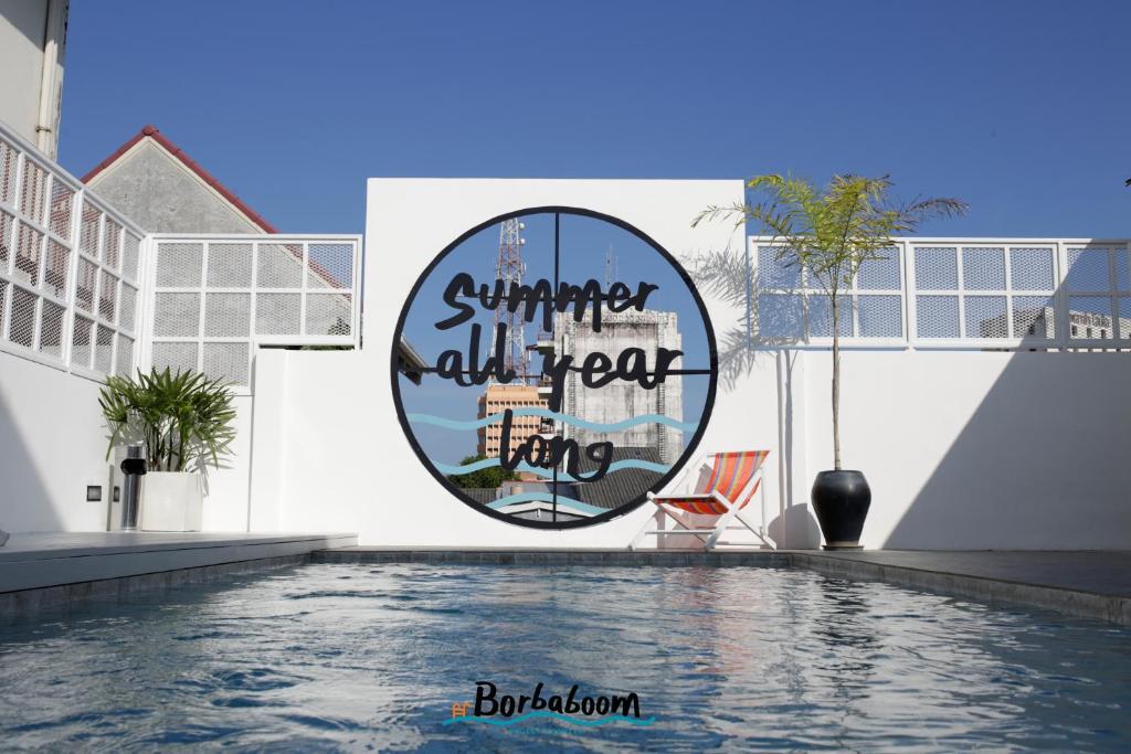 una piscina con un cartel que lee verano todo el año en Borbaboom Phuket Poshtel & Hostel en Phuket