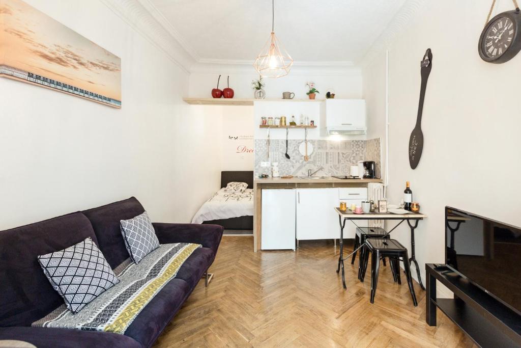 un salon avec un canapé et une table et une cuisine dans l'établissement AMAZING 1 bedroom LOFT in NICE city centre seafront, à Nice