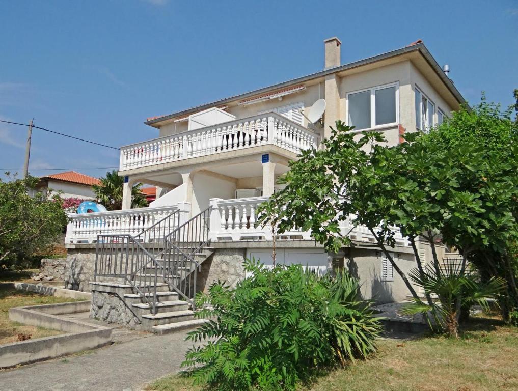 a large white house with a staircase in front of it at Petar in Krk