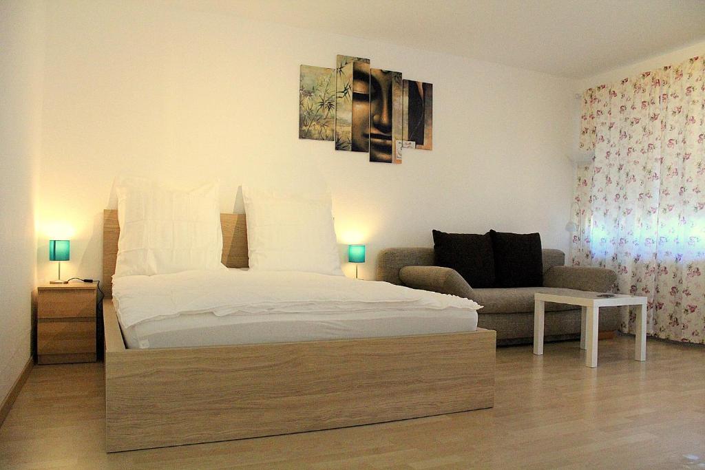 a bedroom with a bed and a couch at Ferienwohnung Engel Lindau am Bodensee in Lindau