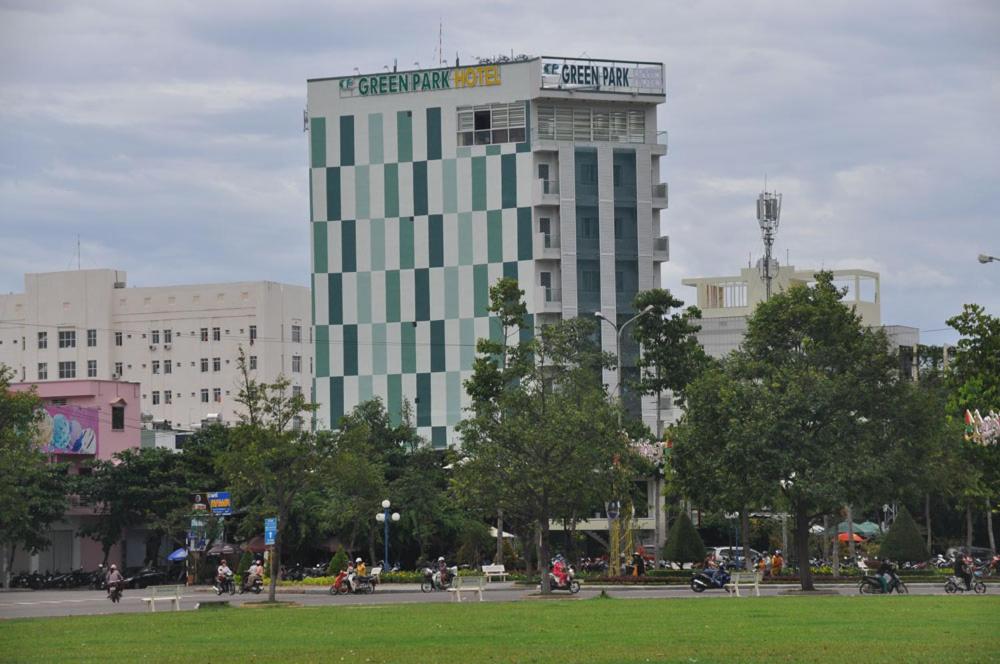 un edificio alto con un cartel en una ciudad en Green Park Hotel Quy Nhon, en Quy Nhon