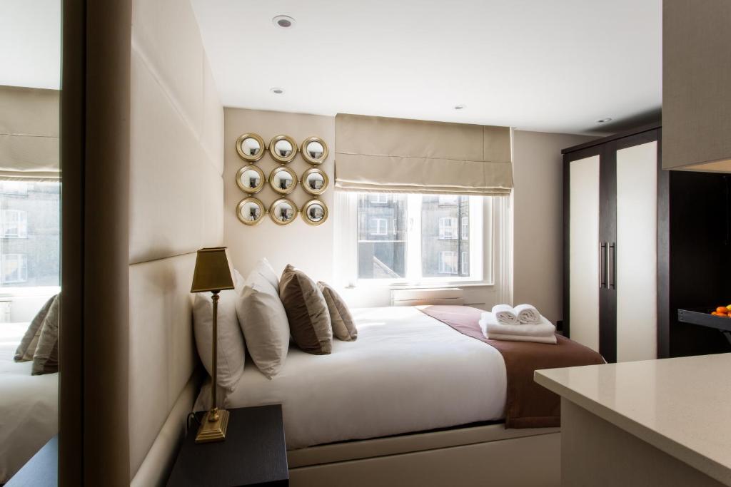 um quarto de hotel com uma cama e uma janela em Baker Street by Viridian Apartments em Londres