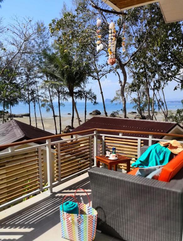a patio with a bench and a table and trees at Krabi Home Resort in Tab Kaek Beach