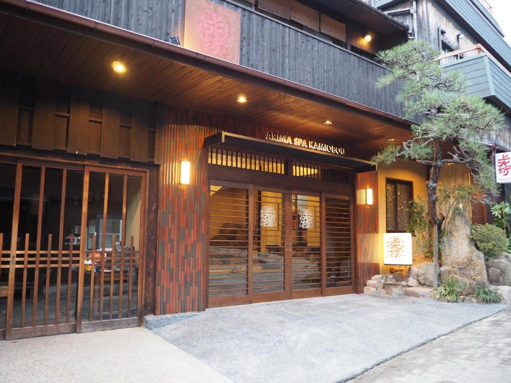 un edificio con puertas de madera y un cartel delante de él en Kamiobo, en Kobe