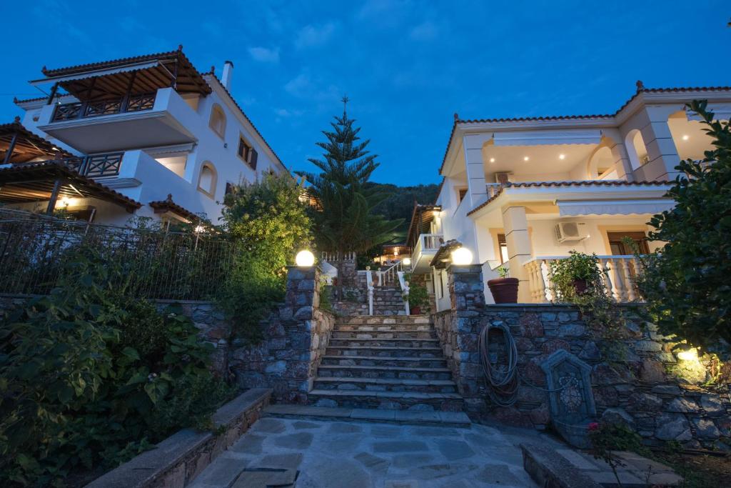 una casa con scale di fronte a un edificio di Niki Apartments a Panormos Skopelos