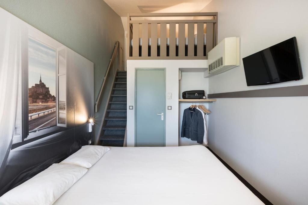 Postel nebo postele na pokoji v ubytování B&B HOTEL AVRANCHES Baie du Mont St-Michel