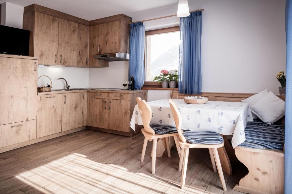 a kitchen and dining room with a table and chairs at Oberhof Weitental in Vallarga