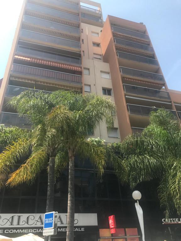 a tall building with palm trees in front of it at Monaco Studio "907" in Monte Carlo