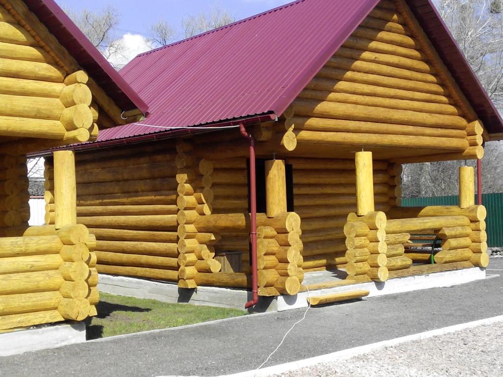 Cabaña de madera con techo rojo en Гостевой дом Фестивальный, en Kiev
