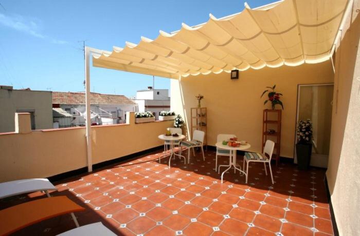 a patio with tables and chairs on a roof at Estuhome in Madrid