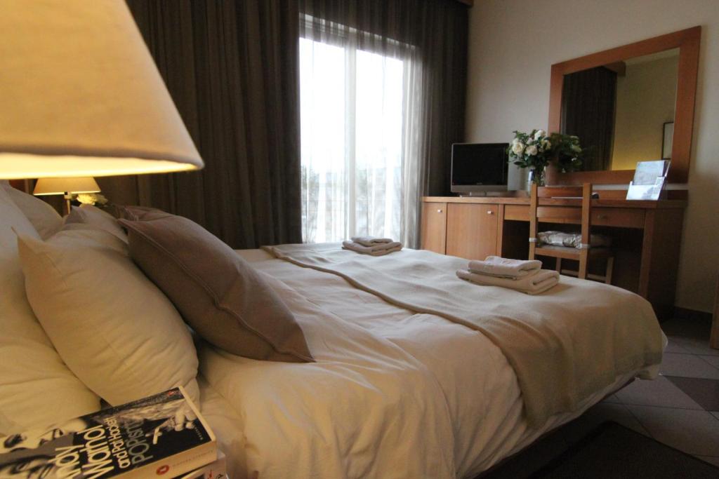 sypialnia z łóżkiem z biurkiem i oknem w obiekcie Achillion Hotel w Atenach