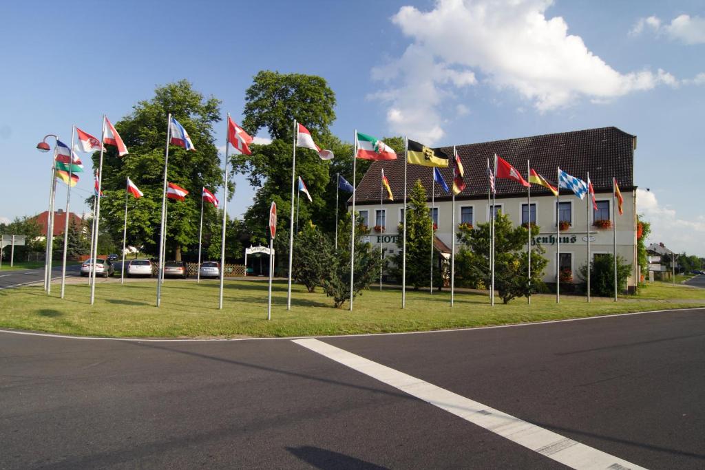 a bunch of flags on poles in front of a building at Döbelts Hotel Schützenhaus Jessen in Jessen