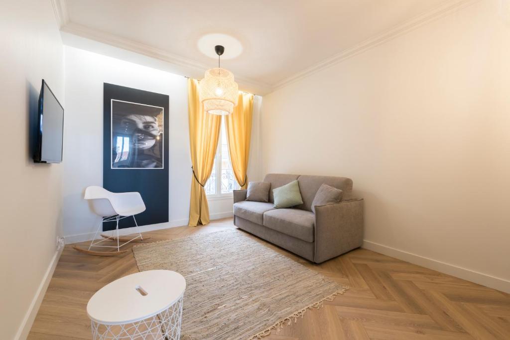 a living room with a couch and a table at F2 chambre en duplex (calme) plein centre ville 1 min de la plage in Saint-Raphaël