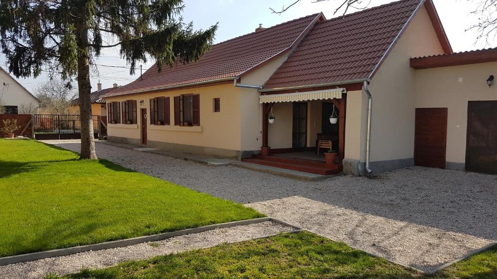 une maison avec une terrasse couverte et une cour dans l'établissement Ilona vendégház Dinnyés, à Dinnyés