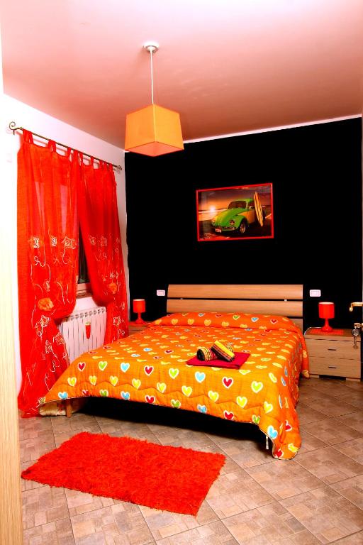 a bedroom with a bed with a yellow comforter and a car at b&b il Maggiolino in Vibo Valentia
