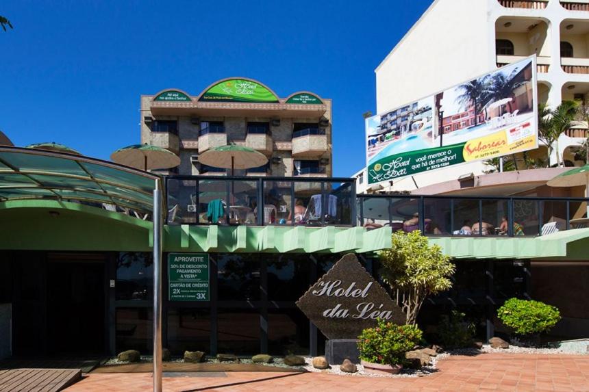 un hotel con un cartel frente a un edificio en Hotel da Lea en Guarapari