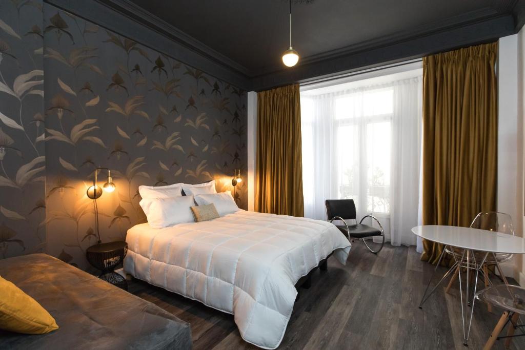 a bedroom with a large bed and a large window at Arome Hotel in Nice