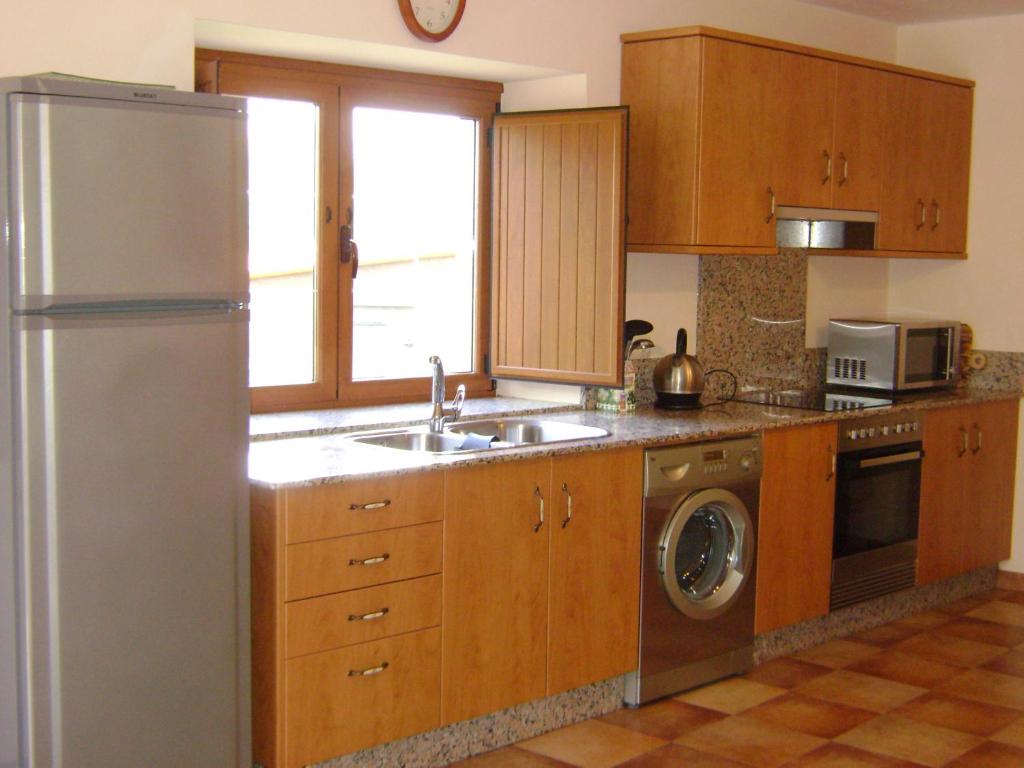 kuchnia z lodówką ze stali nierdzewnej i zmywarką do naczyń w obiekcie Stone Cottage O CEBREIRO w mieście Curtis