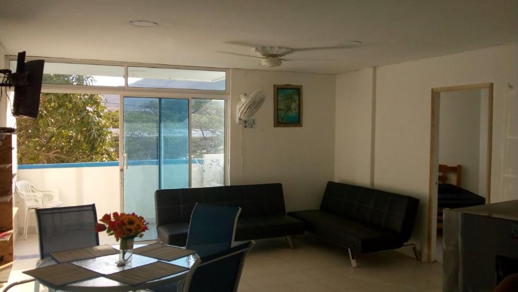 sala de estar con mesa, sillas y ventana en Apartamento 2D Ed.El Lago, en Santa Marta