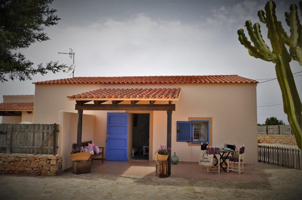 een klein wit huis met een blauwe deur bij Siamoformentera Alessandra in Sant Francesc Xavier