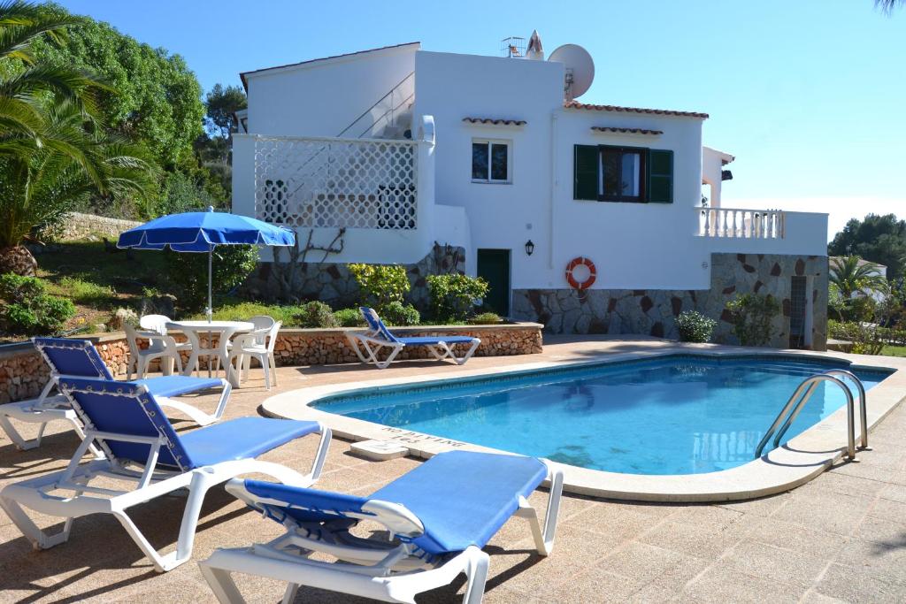 eine Villa mit einem Pool, Stühlen und einem Haus in der Unterkunft VILLA ALONDRA B6 in Santo Tomás