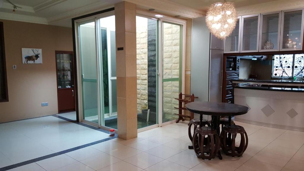 a dining room with a table and a glass door at Seladah Stay in Kuching