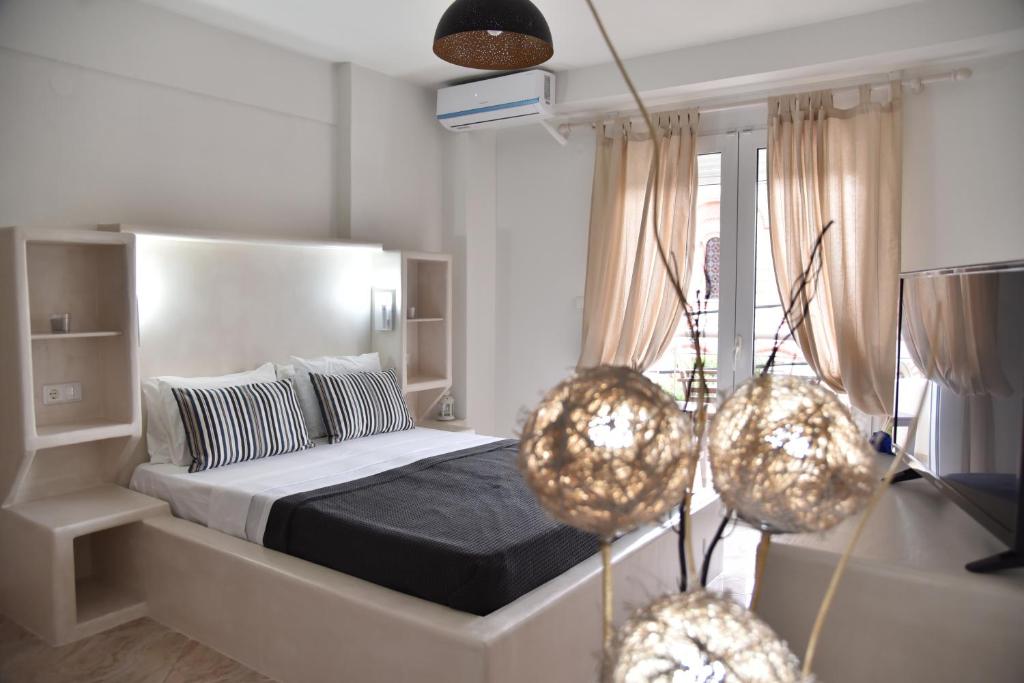 a bedroom with a bed and two hanging lights at KyMa Studios and Suites in Asprovalta