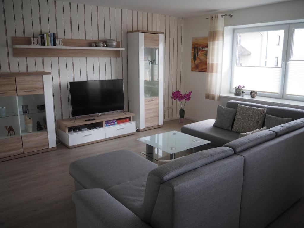 a living room with a couch and a tv at Ferienwohnung Künzell in Künzell