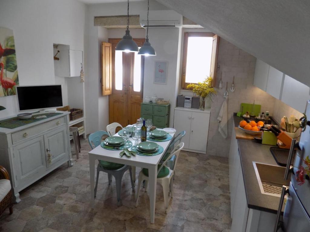 cocina con mesa blanca y sillas en una habitación en Casa Giglio, en Carloforte