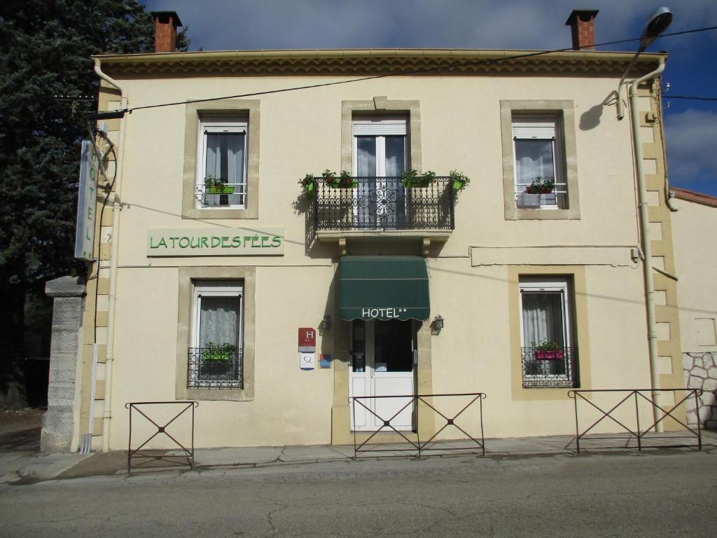 a building with a balcony on the side of it at hôtel la tour des fées in Quissac