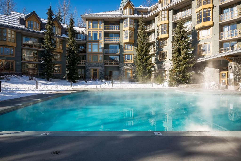 ウィスラーにあるCascade Lodgeのアパートメントの建物の前にスイミングプールがあります。