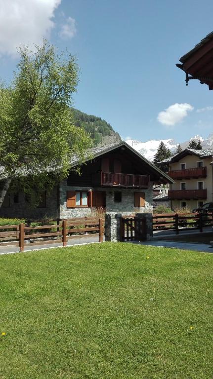 a building with a grass field in front of it at Hygge Chalet a Champoluc in Champoluc