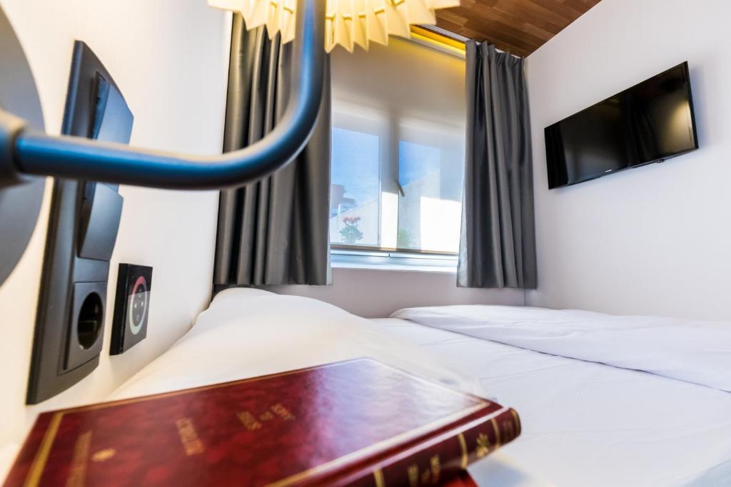 Una habitación de hotel con dos camas y una ventana. en Far Home Bernabeu, en Madrid