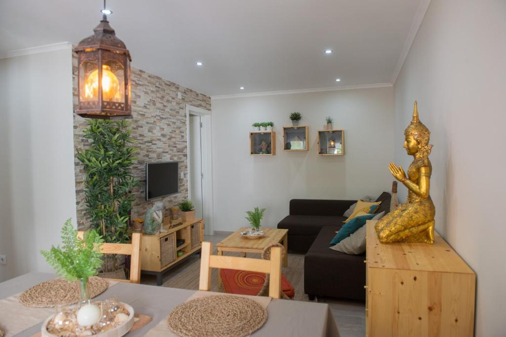 ein Wohnzimmer mit einem Sofa und einem Tisch in der Unterkunft Zen House in Sesimbra