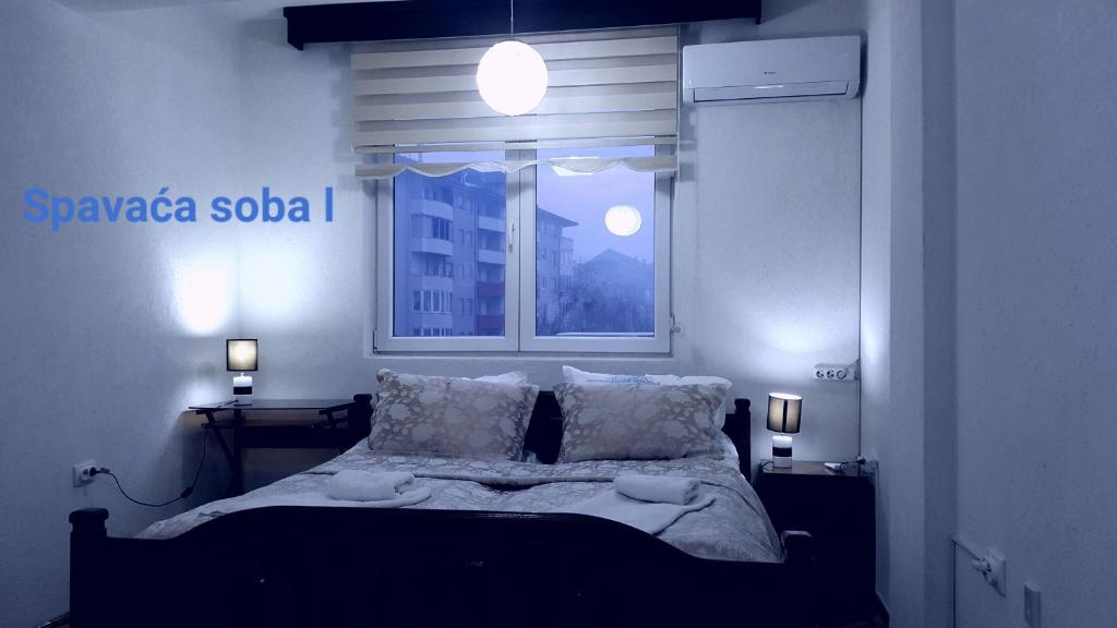 1 dormitorio con 1 cama con ventana y luces en Apartment Idea en Novi Pazar