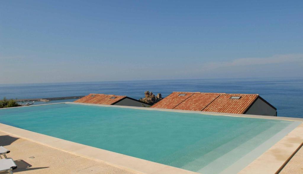 a large swimming pool with the ocean in the background at Destination Cefalu - your best view in Cefalù