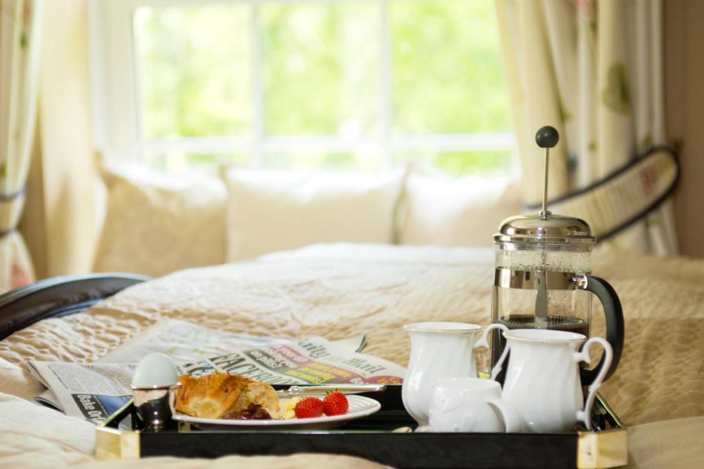 a tray with a plate of food on a bed at Wydemeet Bed and Breakfast in Two Bridges