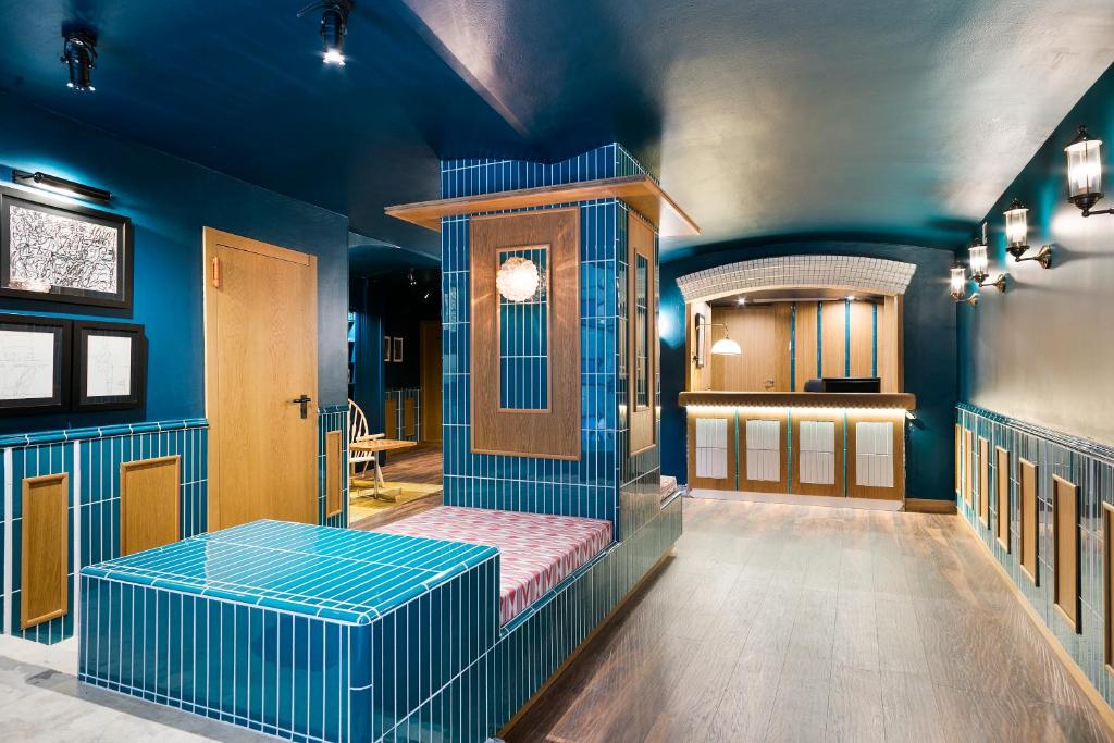 Una habitación azul con una barbería con un banco. en Hotel El Call, en Barcelona
