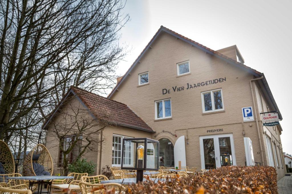 een gebouw met tafels en stoelen ervoor bij Hotel - Restaurant De 4 Jaargetijden in Epen