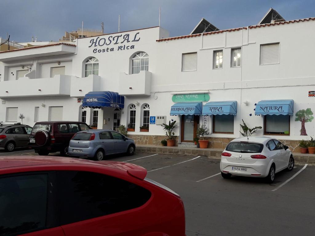 a large white building with cars parked in a parking lot at Hostal Costa Rica in San José