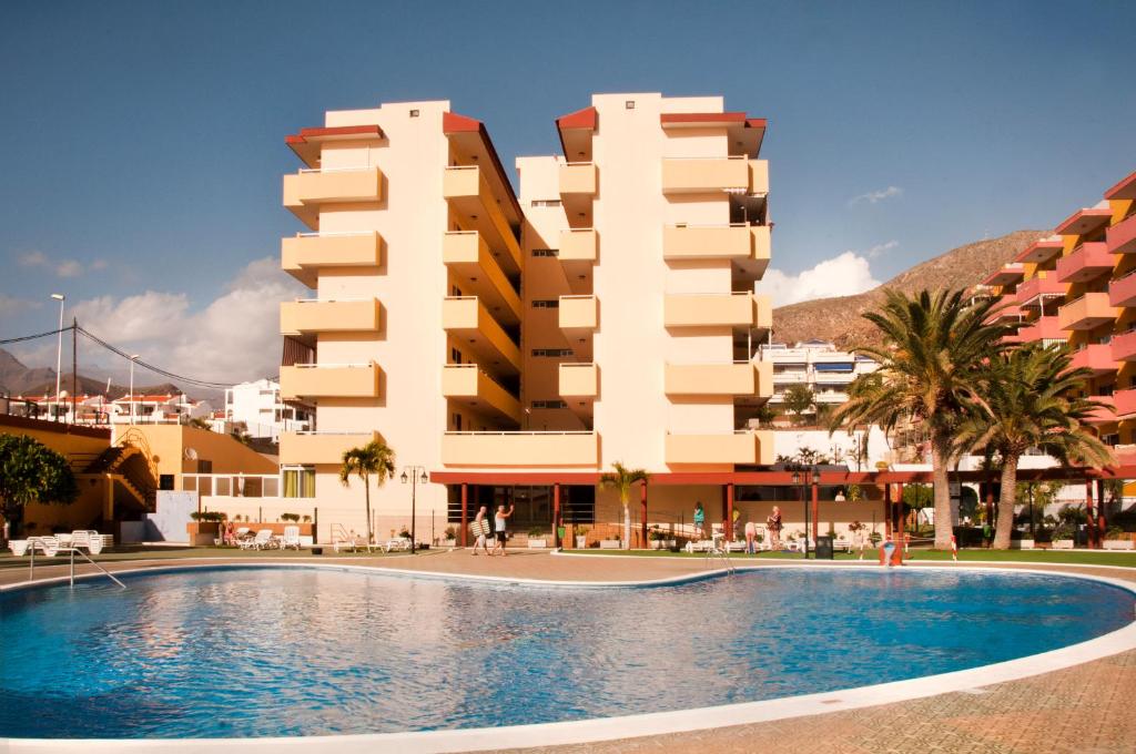ロス・クリスティアーノスにあるApartments In Los Cristianos, Tenerife, Canary Islandsの建物の前にスイミングプールがあるホテル